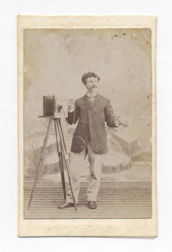 1860&rsquo;s CDV: PHOTOGRAPHER STANDS BY STUDIO CAMERA AS HE HOLDS A PHOTO